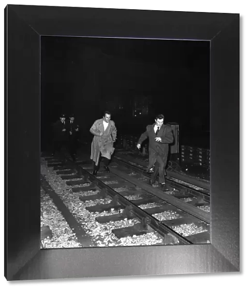 Lawrence Harvey (front) and John Ireland being chased by police along underground train