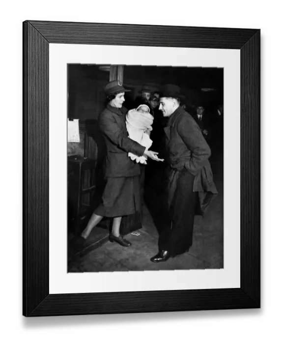 Framed Print : Ticket collector'. The woman comes to the rescue she is holding the baby Framed Print : Ticket collector'. The woman comes to the rescue she is holding the baby