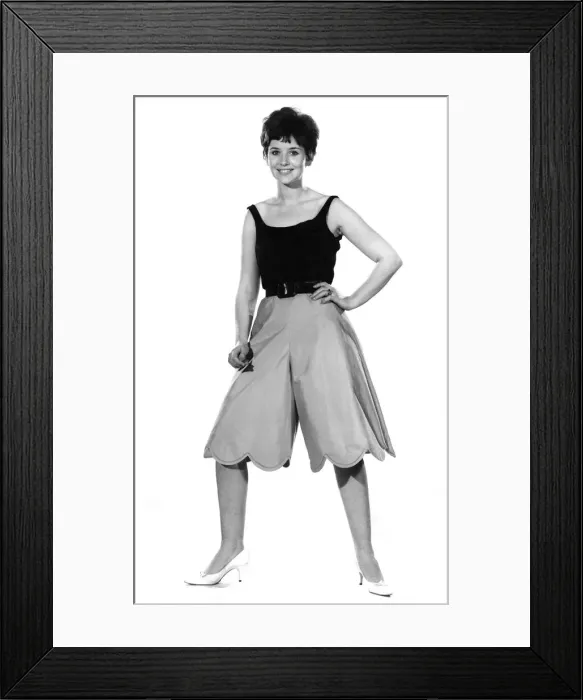 Framed Print : Reveille Fashions. Ann Cave models vest top and baggy shorts. August 1962 P011086