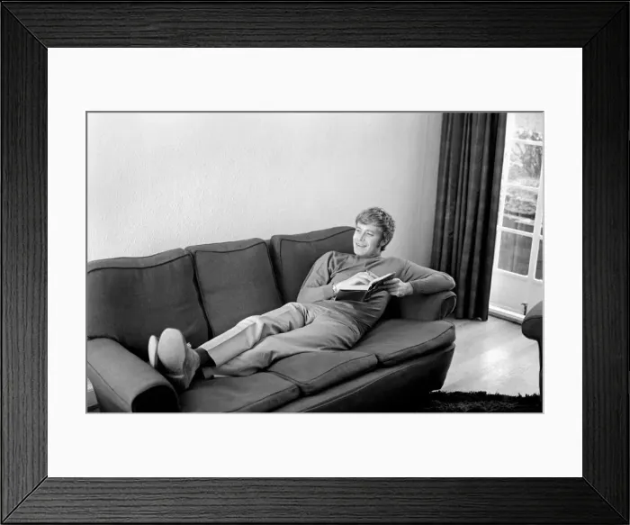 Framed Print : Families: Mother, father and childrens. Man relaxing at home, reading a book on his sofa Framed Print : Families: Mother, father and childrens. Man relaxing at home, reading a book on his sofa