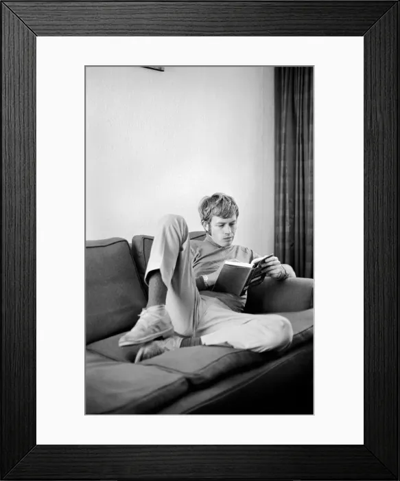 Framed Print : Families: Mother, father and children. Man relaxing at home, reading a book on his sofa Framed Print : Families: Mother, father and children. Man relaxing at home, reading a book on his sofa