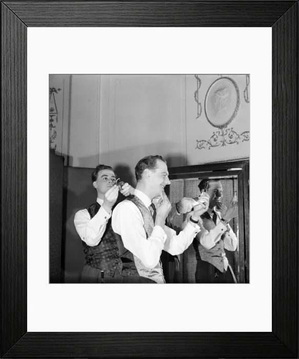 Framed Print : Clothing: Fashion: Men. Two of the male mannequins preparing themselves for the first