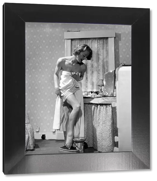 Women: Weight. Actress Pat Dainton weighting herself. October 1953 D5991