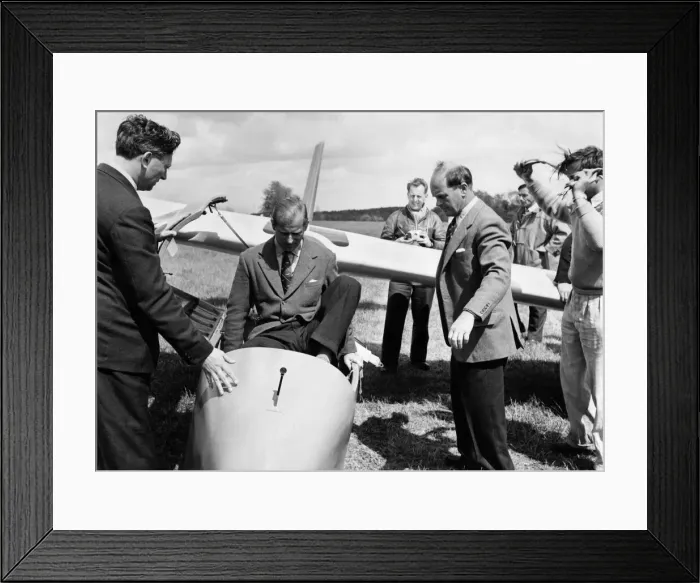 Framed Print : Prince Philip climbs into the cockpit while Peter Scott Looks on (right) Framed Print : Prince Philip climbs into the cockpit while Peter Scott Looks on (right)