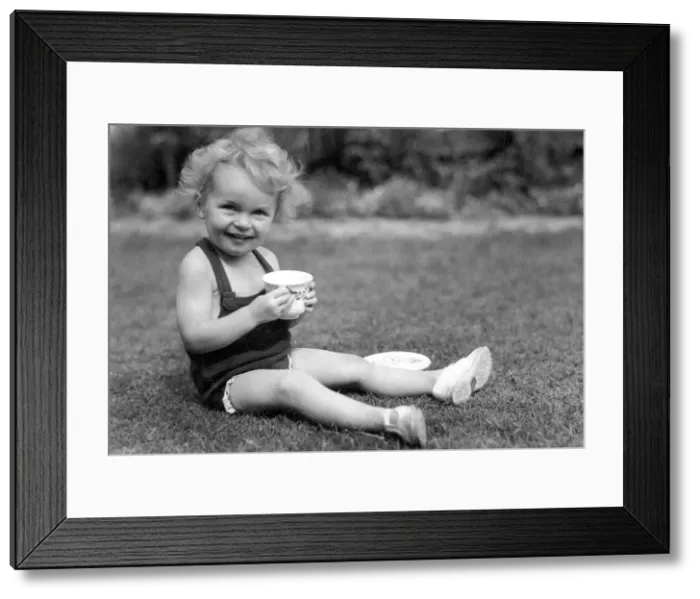 Framed Print : Young girl sitting in her back garden drinking from a cup Circa 1945 P044434 Framed Print : Young girl sitting in her back garden drinking from a cup Circa 1945 P044434