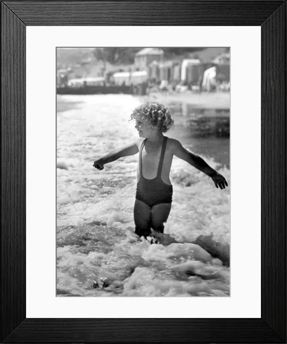 Framed Print : Brave young girl goes for a paddle in the sea while on holiday Circa 1945 Framed Print : Brave young girl goes for a paddle in the sea while on holiday Circa 1945