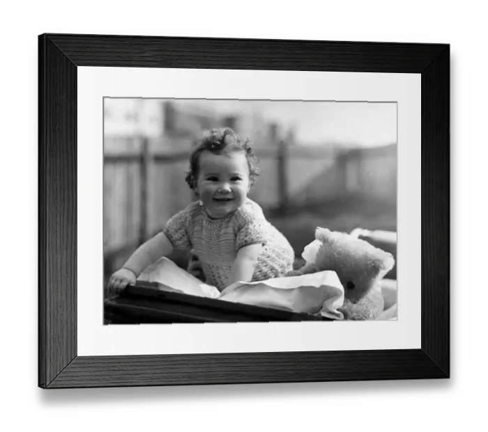 Framed Print : Young girl in her pram with her favourite teddy bear Circa 1945 P044429