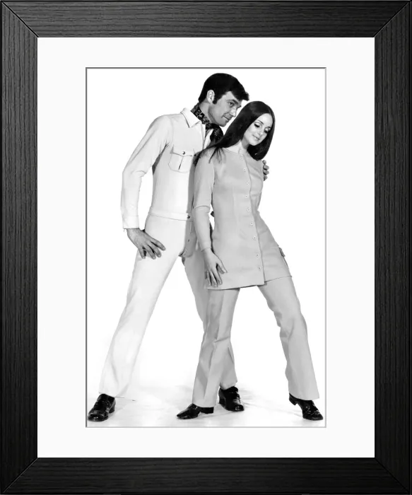 Framed Print : Clothing. John and Shirley are ready to go in Jersey. His beige Swedish stretch jump suit Framed Print : Clothing. John and Shirley are ready to go in Jersey. His beige Swedish stretch jump suit
