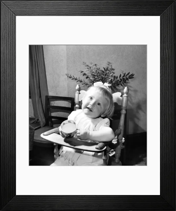 Framed Print : Small girl enjoying a cup of tea. August 1953 D5235-002