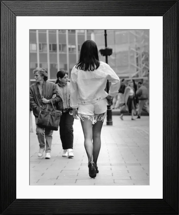 Framed Print : Tracy strutting her stuff on busy steet wearing white denim jacket
