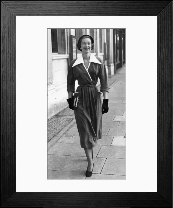 Framed Print : A woman walking along street showing off the latest in fashion Framed Print : A woman walking along street showing off the latest in fashion