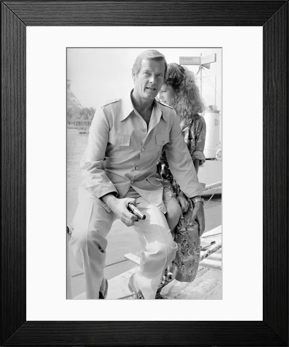 Framed Print : Roger Moore with actress Lois Chiles at a photocall and reception held in Paris to