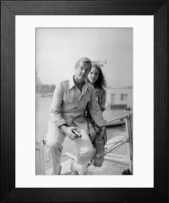 Framed Print : Roger Moore with actress Lois Chiles at a photocall and reception held in Paris to