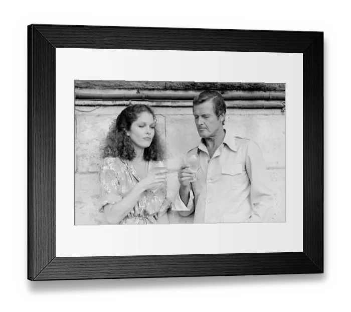 Framed Print : Roger Moore with actress Lois Chiles at a photocall and reception held in Paris to