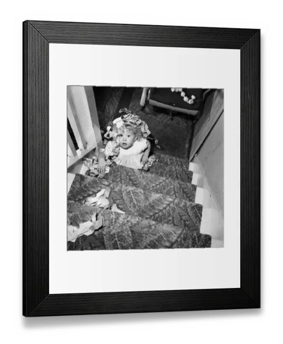 Framed Print : 15 month-old Janice Cook with Christmas chains climbing the stairs November 1953 Framed Print : 15 month-old Janice Cook with Christmas chains climbing the stairs November 1953