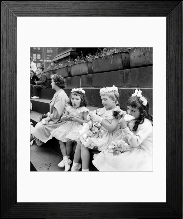Framed Print : Young girls dressed in their sunday finest enjoy a sandwich after taking part in Framed Print : Young girls dressed in their sunday finest enjoy a sandwich after taking part in