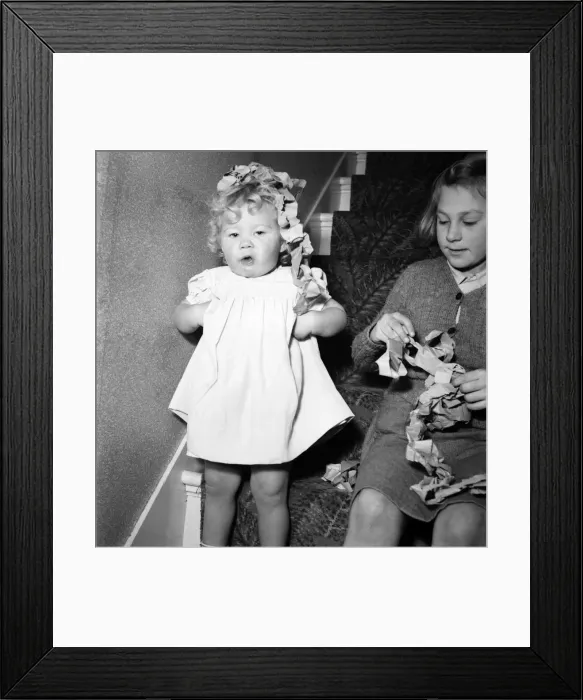 Framed Print : 15 month-old Janice Cook with Christmas chains playing in the living room November Framed Print : 15 month-old Janice Cook with Christmas chains playing in the living room November