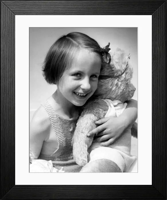 Framed Print : Young girl holding her teddy bear Circa 1945 P044428