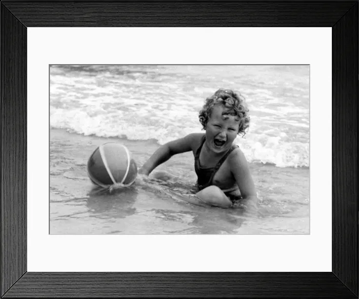 Framed Print : Yound girl playing with her beach ball during a holiday at the seaside Circa 1945