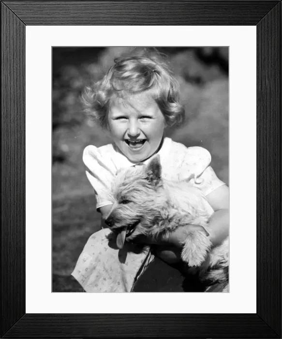 Framed Print : Happy young girl holding onto her pet dog Circa 1945 P044448