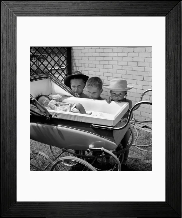 Framed Print : Three gloomy-faced triplet brothers aleaning over the side of a pram in the garden of Framed Print : Three gloomy-faced triplet brothers aleaning over the side of a pram in the garden of