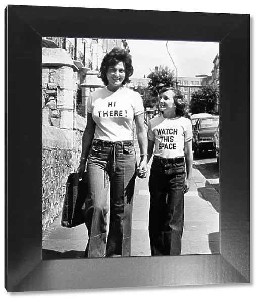 Women walking down the street wearing t shirts with amusing slogans August 1976