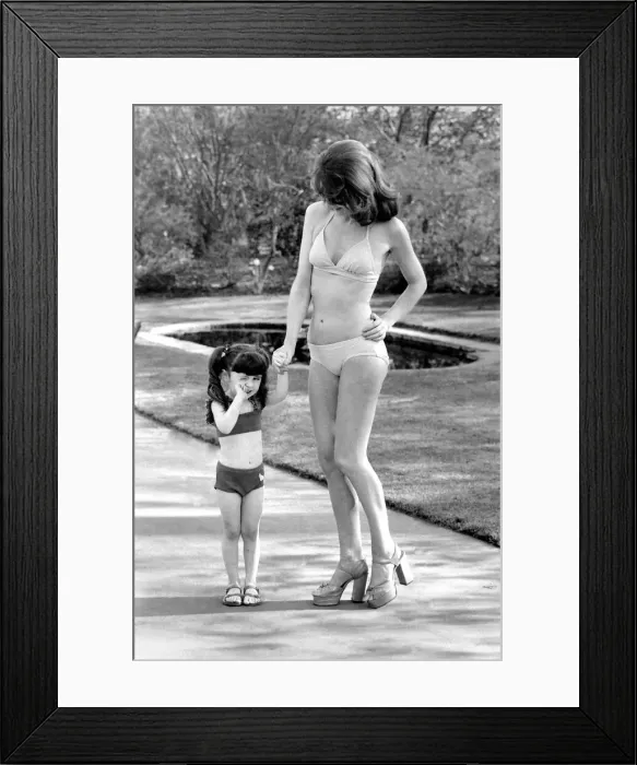 Framed Print : Fashion scene from Woolworth s. Woman wearing a bikini standing in the park with a Framed Print : Fashion scene from Woolworth s. Woman wearing a bikini standing in the park with a