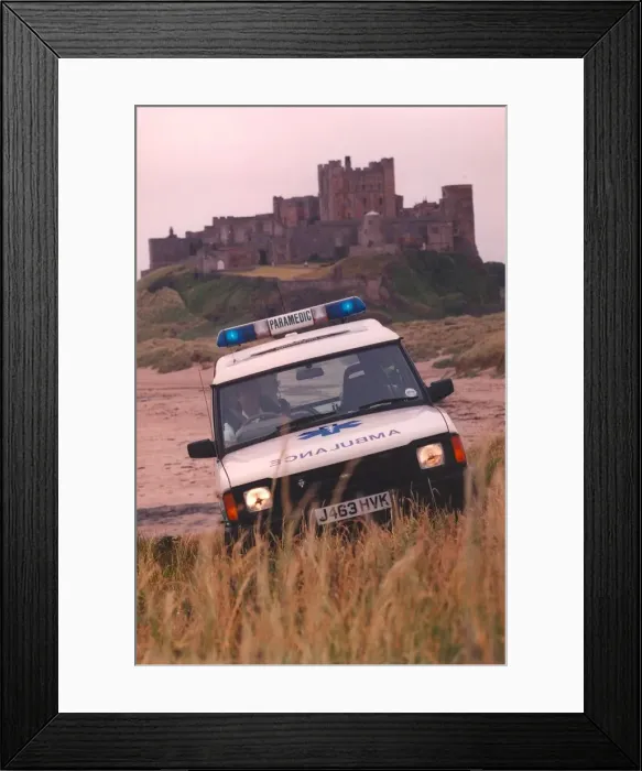 Framed Print : Beach combing - one of the new 4 wheel drive ambulances in action at Bamburgh Castle