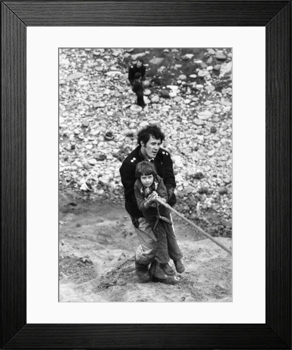 Framed Print : Firefighter Jeff Kipling helps as seven-year old Peter Harrison is hauled up the Ryhope