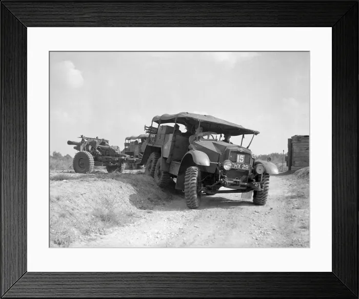 Framed Print : British army soldiers inside an all terrain vehicle pulling along a howitzer gun during