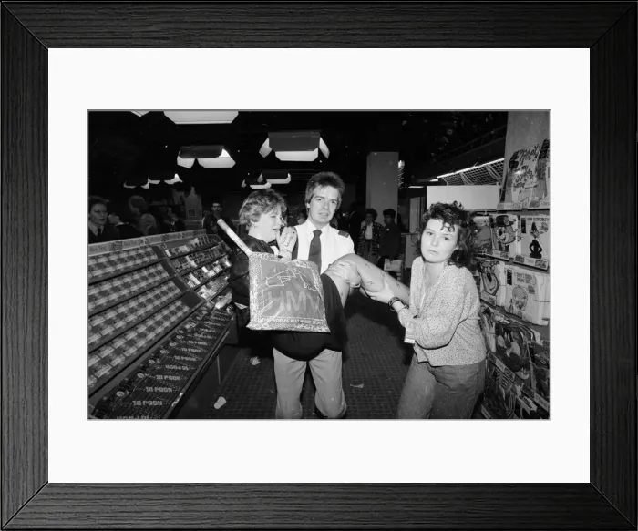 Framed Print : An emotional fan of the pop group Bros is carried away from a record store by a security Framed Print : An emotional fan of the pop group Bros is carried away from a record store by a security