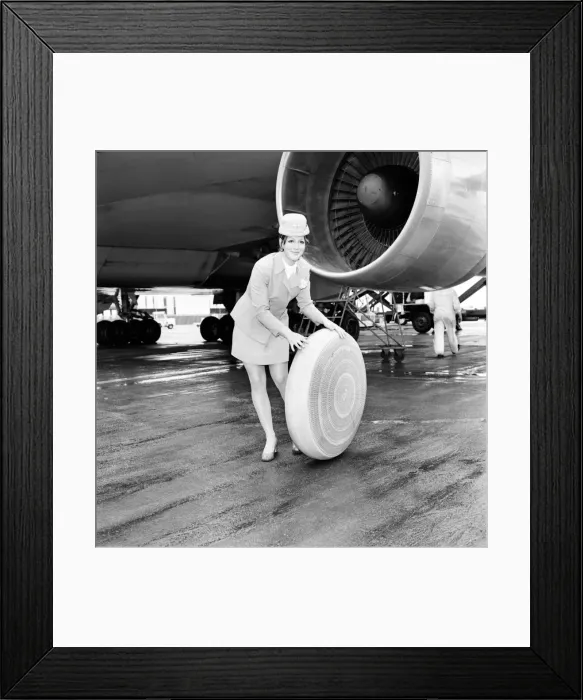 Framed Print : Air hostess sitting by a plane rolling a wheel along. A 2 *** Local Caption Framed Print : Air hostess sitting by a plane rolling a wheel along. A 2 *** Local Caption