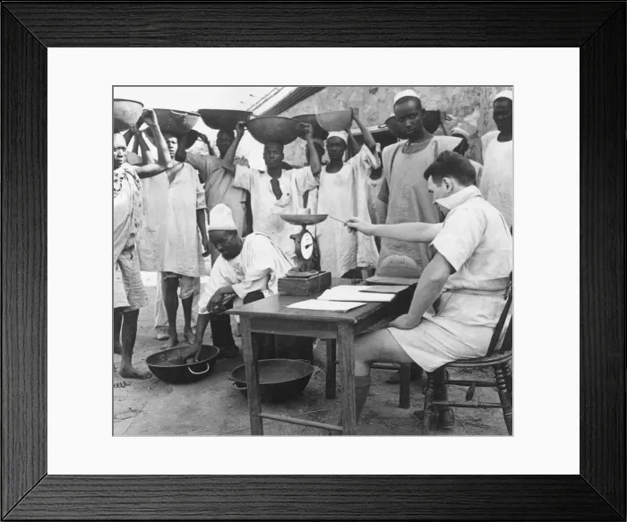Framed Print : Tributors having their concentrate assessed and weighed by the manager of a columbite