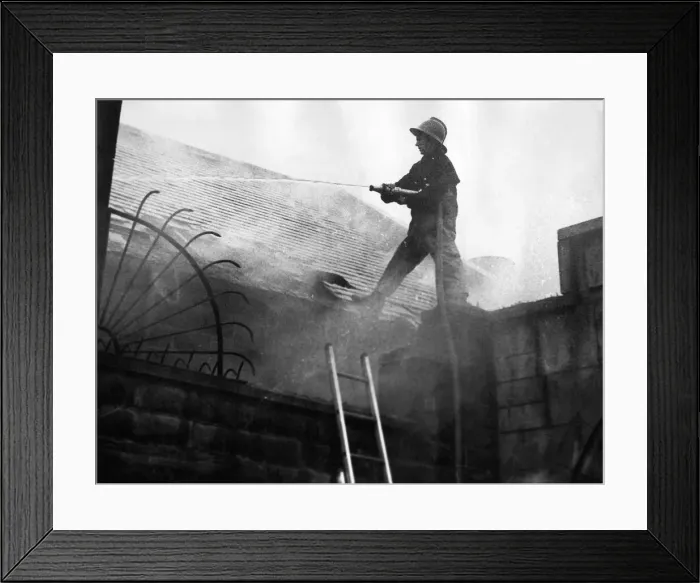 Framed Print : Firefighters clambered over the roofs high above the city to tackle a blaze that Framed Print : Firefighters clambered over the roofs high above the city to tackle a blaze that