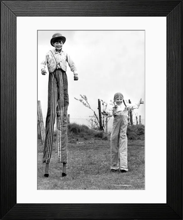 Framed Print : Peter and Julie Ann Jolly on stilts in their dads circus Framed Print : Peter and Julie Ann Jolly on stilts in their dads circus