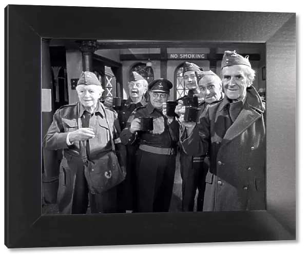 Stars of the popular wartime comedy television programme Dads Army toast each other after