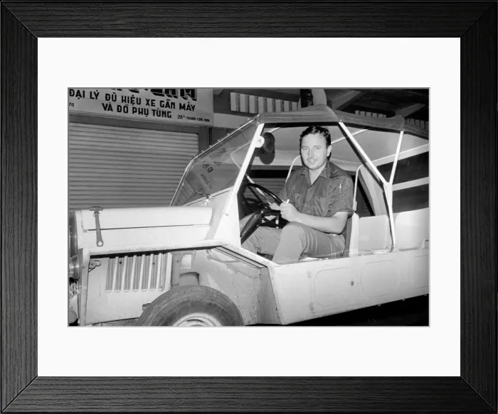 Framed Print : Night life in Saigon Vietnam. Man drives a jeep in the street