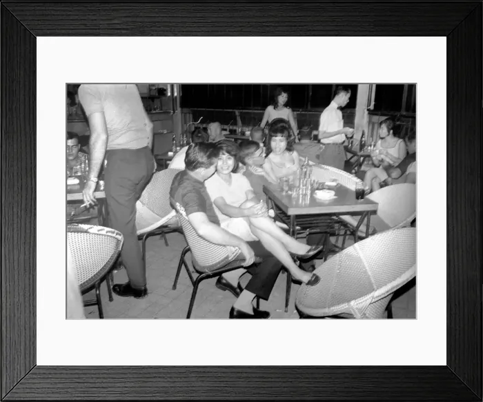 Framed Print : Night life in Saigon Vietnam. Local women sit on the laps of visiting men