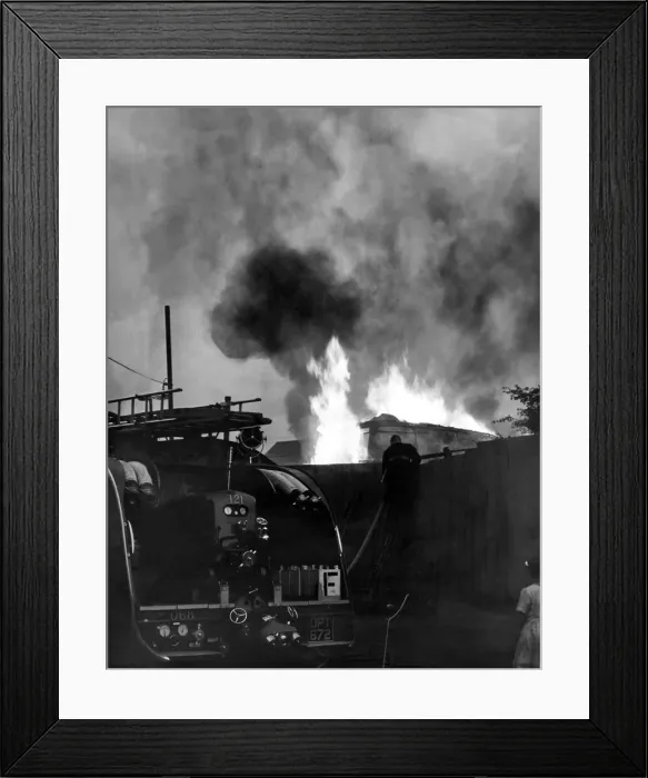 Framed Print : Firefighters contain a fire at a double-decker bus used as a storehouse at Washington