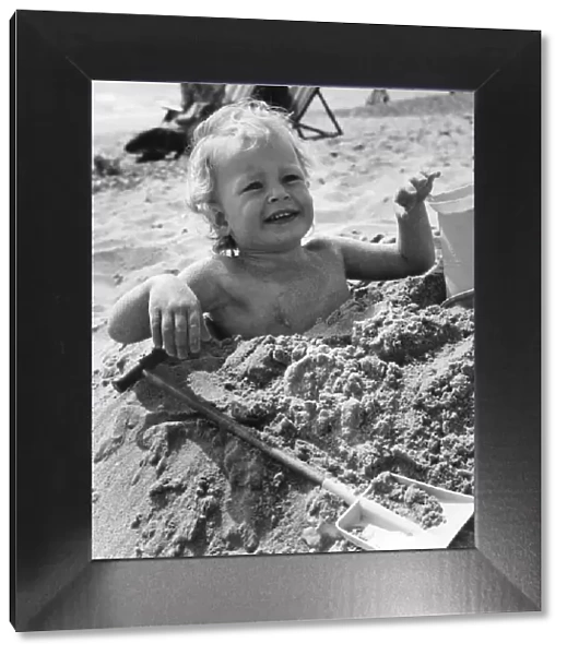 3 year old Bradley Hook up to his arm-pits in the sand at Bournemouth. April 1971 P023604