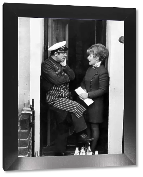 Norman Wisdom: Norman chats to Mrs. Agnes Kirwan on the doorstep. December 1972