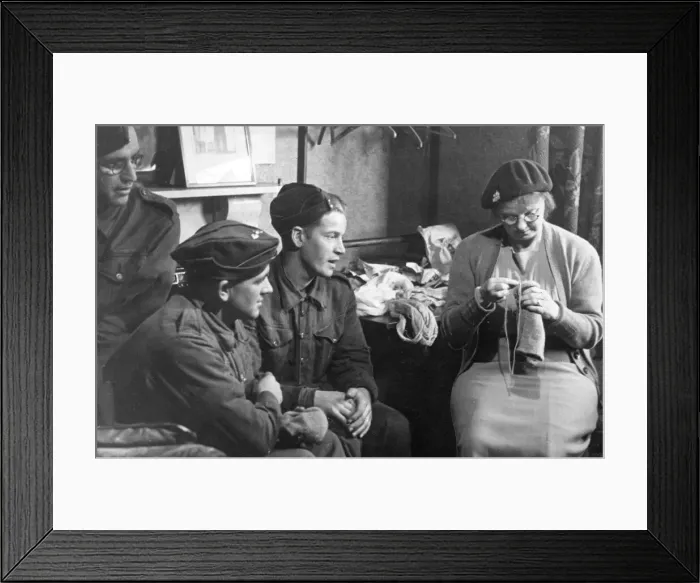 Framed Print : Mend-while-you-wait service. Mrs Baker, Tonbridge, darns a sock while Privates Wozencroft Framed Print : Mend-while-you-wait service. Mrs Baker, Tonbridge, darns a sock while Privates Wozencroft