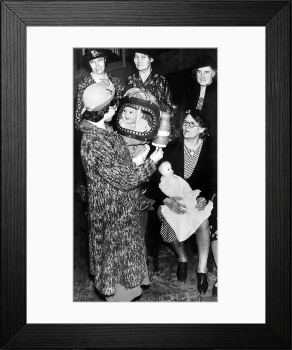 Framed Print : A baby in a gas mask smiles at her mother. 25th August 1939 Framed Print : A baby in a gas mask smiles at her mother. 25th August 1939