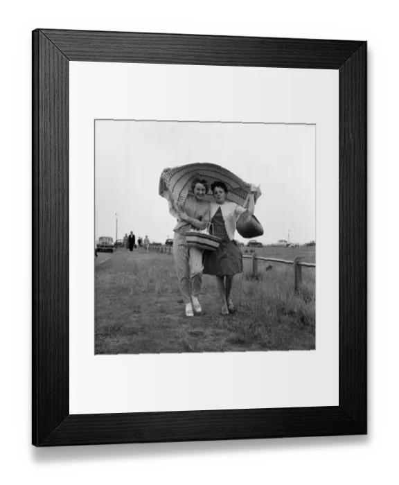 Framed Print : Holidaymakers covering their heads run for cover after being caught in a shower