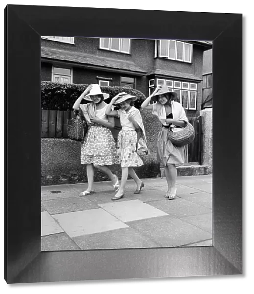 Three women hold on to their hats on the seafront at Haylake. June 1960 M4313-003