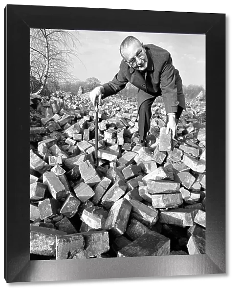People - elderly. An old man searching through a pile of bricks. December 1969 Z11973-001