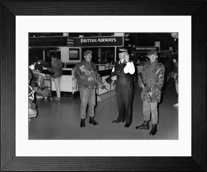 Framed Print : Soldiers with machine guns tand alongside an armed police officer as security is Framed Print : Soldiers with machine guns tand alongside an armed police officer as security is
