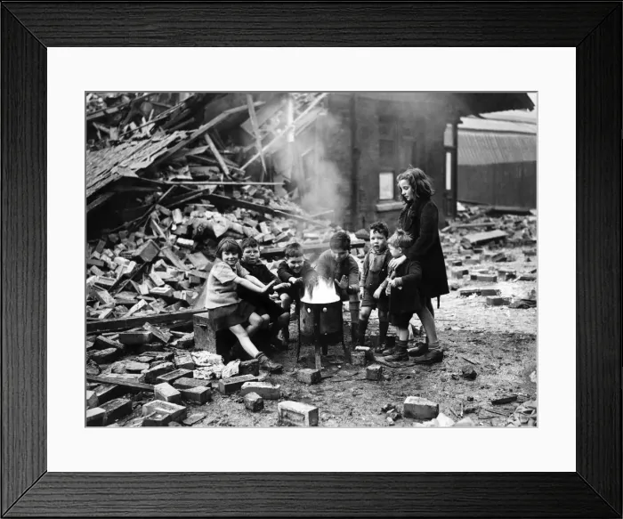 Framed Print : Manchester children warm themselves by the brasier following an air raid on the city