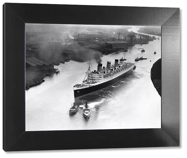 The Cunard White Star Liner the RMS Queen Mary makes her way down the River Clyde to
