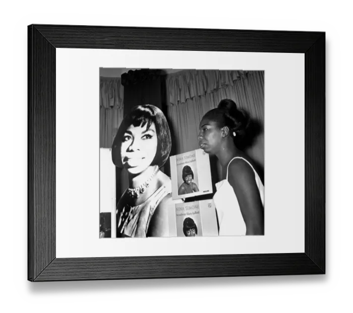 Framed Print : Singer Nina Simone stands besides a poster advertising on of her records at a press